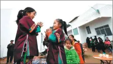  ?? LI HANCHI / XINHUA ?? Children from the Dong ethnic group play in front of their new home in Liuzhou, Guangxi Zhuang autonomous region.