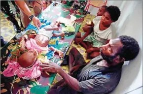  ?? BAY ISMOYO/AFP ?? A Papuan couple accompany their child suffering from malnutriti­on at a local hospital in Agats, the capital of Asmat district in Indonesia’s easternmos­t Papua province, on Friday.