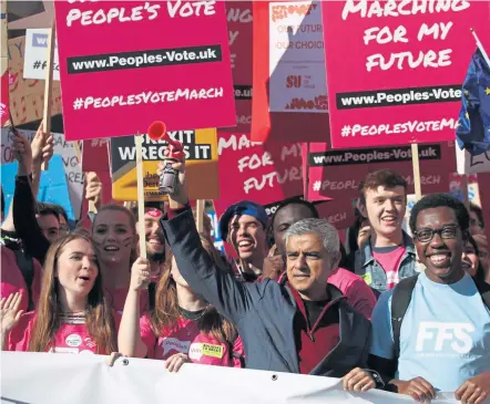  ?? YUI MOK / PA ?? ANOTHER CHANCE: London Mayor Sadiq Khan, front center, holds a klaxon horn as he joins protesters seeking another referendum on Brexit in London yesterday.