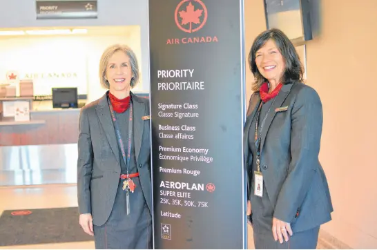  ?? NICOLE SULLIVAN • CAPE BRETON POST ?? Clare MacDougall, left, and Leslie MacArthur stand next to a priority boarding sign for Air Canada Jazz at the J.A. Douglas McCurdy airport on Tuesday, where they have worked for 35 years.