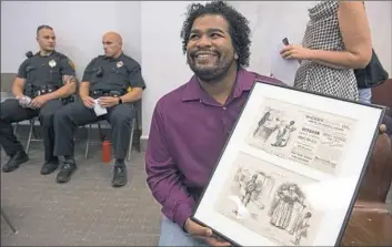  ?? Steph Chambers/Post-Gazette ?? Jonathan Reyes of McKeesport, arts and culture facilitato­r of the Braddock Carnegie Library, shows an 1873 Harper's Weekly of "blacks dehumanize­d" before a hearing Wednesday on the Stephen Foster statue.