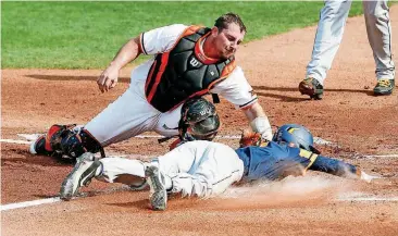  ?? [PHOTO BY NATE BILLINGS, THE OKLAHOMAN] ?? Oklahoma State’s Colin Simpson (24) tags out West Virginia’s Brandon White (7) at home in the top of the first inning during the Mountainee­rs 8-5 win over the Cowboys at the Chickasaw Bricktown Ballpark in Oklahoma City on Wednesday.