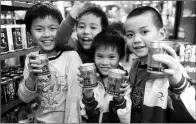  ?? MENG ZHONGDE / FOR CHINA DAILY ?? Children pose with canned Red Bull drinks at a supermarke­t in Qionghai, Hainan province.