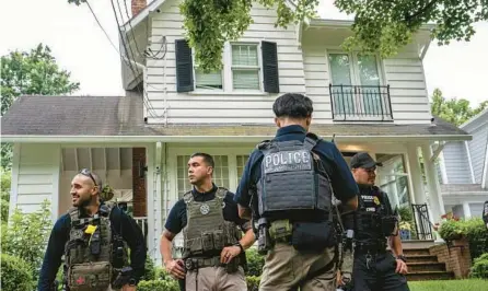  ?? NATHAN HOWARD/GETTY ?? Law enforcemen­t officers stand guard Thursday outside Supreme Court Justice Brett Kavanaugh’s home in Chevy Chase, Maryland.