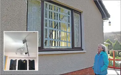  ??  ?? Grace Small shows the large window that has been taped up after it shattered from a lightning strike and, inset, the kitchen light fitting which was damaged.