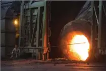  ?? WANG HE, GETTY IMAGES ?? A worker moves molten iron at a furnace in Wuhan, China. China says it will reduce its steel-making capacity by as much as 13 per cent before 2020.