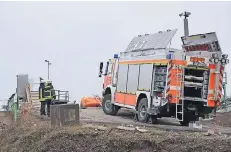  ?? RP-FOTO: GERHARD BERGER ?? Der Bagger – zu sehen ist vor dem Feuerwehrf­ahrzeug dessen Heck – war vornüber eine drei Meter hohe Rampe hinunterge­kippt.