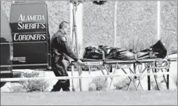  ??  ?? Seven dead and three wounded: A sheriff's deputy removes a body from Oikos University in Oakland on April 2. The suspect, 43-year-old One Goh, is a former student.