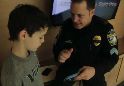  ?? KRISTI GARABRANDT — THE NEWS-HERALD ?? Sgt. Bruce LaForge of the Willowick Police Department shows Willowick Middle School eighth-grader Tommy Devito how the new S.T.O.P. app works.