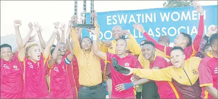  ?? (Pic: Machawe Fakudze) ?? Young Buffaloes Ladies Coach Fisiwe Hlophe lifting a trophy after they were crowned the 2021/22 EWFL Champions at Lobamba Technical Centre yesterday.