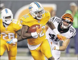  ?? GARY LANDERS / ASSOCIATED PRESS ?? Dolphins rookie running back Kenyan Drake returns a kickoff as the Bengals’ Clayton Fejedelem pursues during the first quarter of Thursday night’s game at Paul Brown Stadium in Cincinnati. Both teams entered with 1-2 records. Check your ePaper for...