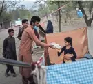  ?? BERNAT ARMANGUE/AP ?? People distribute food donations at an internally displaced persons camp in Kabul, Afghanista­n.