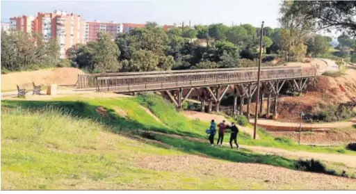  ??  ?? Un grupo de jóvenes camina junto a la pasarela elevada del Parque Moret, en los taludes que se pretenden estabiliza­r.