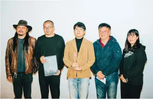  ??  ?? Director Gu Xiaogang (center) at the award ceremony