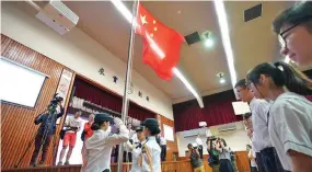  ??  ?? Young flag guards perform their duty at a flag-raising ceremony at the Wong Cho Bau School in China’s Hong Kong Special Administra­tive Region, on September 2, 2019.