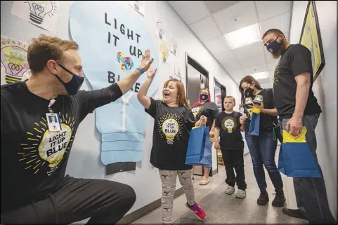  ?? PHOTOS BY STEVE MARCUS ?? Alivia Grimm, 6, gives a high-five to behavior analyst Adam Volker Thursday at the Center for Autism and Developmen­tal Disabiliti­es at Touro University Nevada in Henderson. Touro recently was awarded a $3 million grant from Qatar to help address autism spectrum disorder.