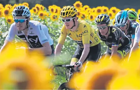  ??  ?? Great Britain’s Geraint Thomas, wearing the overall leader’s yellow jersey, follows team-mate Luke Rowe.