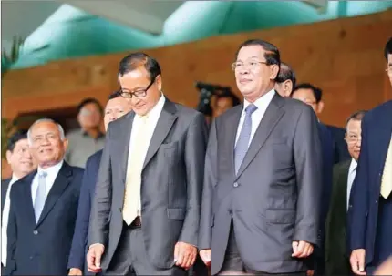  ?? HENG CHIVOAN ?? Hun Sen and Sam Rainsy stand on the steps of the National Assembly after a meeting in 2014.