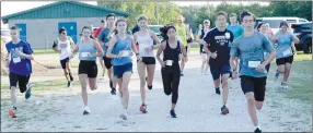  ?? Westside Eagle Observer/MIKE ECKELS ?? Runners take off from the concession stand parking lot at Edmiston Park Ball Park for the start of the 68th Decatur Barbecue 5K run Aug. 6 in Decatur.