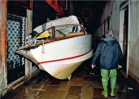  ??  ?? Acqua alta
Nella foto in alto a sinistra. turisti a San Marco. A destra e sotto (foto grande) gondole e un motoscafo strappati agli ormeggi