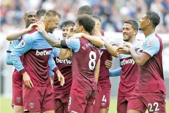  ??  ?? West Ham United’s Ukrainian striker Andriy Yarmolenko (L) celebrates with teammates after scoring his team’s first goal during the English Premier League football match between West Ham United and Manchester United at The London Stadium last Sunday. - AFP photo