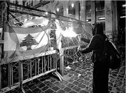  ?? HASSAN AMMAR/AP ?? An anti-government protester uses an ignited aerosol can to shoot a stream of fire at the riot police during protests Sunday in Beirut against the ruling political elites.