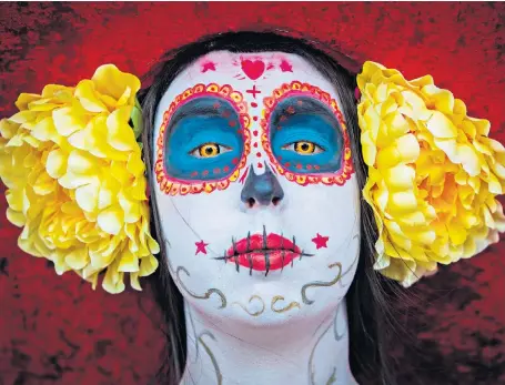  ??  ?? A fan of The Book of Life, an animated comedy set in Mexico, is made up to look like the character La Muerte for the Manchester Comic Con event at the MCM centre where thousands of comic book and fantasy enthusiast­s gathered.