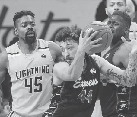  ?? DEREK RUTTAN/THE LONDON FREE PRESS/POSTMEDIA NETWORK ?? Ryan Anderson of the Windsor Express juggles a rebound in front of the London Lightning’s Marvin Phillips in the second half of their NBL game at Budweiser Gardens in London on Sunday. The Lightning defeated the Express 132-109.