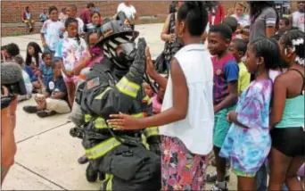  ?? KEVIN TUSTIN — DIGITAL FIRST MEDIA ?? Students know that firefighte­r Frank Lanni isn’t scary in all of his turnout gear that he uses to fight fires in their community. Some of the kids noted that it was “too hot” to be wearing all that gear.