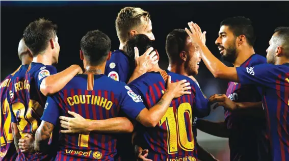  ??  ?? FC Barcelona’s Lionel Messi, centre right back, celebrates with teammates after scoring against Alaves