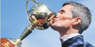  ?? Picture: EPA-EFE ?? SPOILS OF VICTORY. Corey Brown kisses the Melbourne Cup.