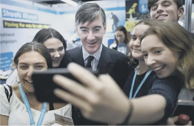  ??  ?? 0 Leader of the House of Commons Jacob Rees-mogg poses for a photograph with some young admirers during the Conservati­ve Party conference