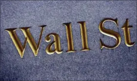  ?? MARK LENNIHAN — THE ASSOCIATED PRESS FILE ?? A sign for Wall Street is carved into the side of a building in New York.