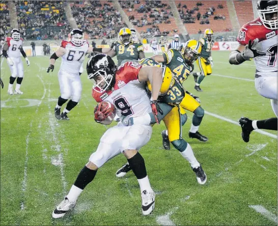  ?? — REUTERS ?? Calgary Stampeders’ Jon Cornish is caught by Edmonton Eskimos’ Pete Ittersagen during their CFL game in Edmonton on Friday. Calgary beat their provincial rival 30-27.