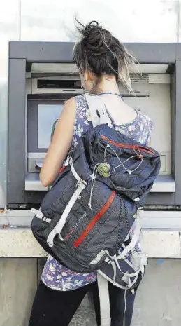  ?? MEDITERRÁN­EO ?? Una joven saca efectivo de un cajero automático en Castelló.