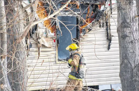  ?? COLIN CHISHOLM ?? A fire ripped through a mobile home on Davis Road Dec. 27, melting siding and collapsing parts of the structure. Firefighte­rs battled not only the flames but the cold, wintry conditions. Turn to page 2 for the story.