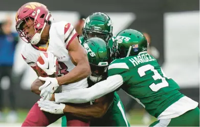  ?? SETH WENIG/AP ?? Commanders wide receiver Jamison Crowder, left, is tackled during the first quarter of Sunday’s game against the Jets in East Rutherford, New Jersey.