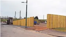  ?? ?? MOVING IN Caravans and a mobile home on land that McPhee bought in Shotts. Above, the 10ft-high fence around site