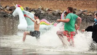  ?? AMBER QUAID/CONTRIBUTI­NG PHOTOGRAPH­ER ?? Ian Emerson, 12, leads members of Team Friendship into Lake Dardanelle for their turn to take the plunge during the Russellvil­le Polar Plunge on Feb. 6. He was followed by his dad, Dustin, from left, and fellow teammates Marty Duane (green shirt) and Carly Nehus.