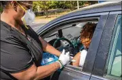  ?? ALYSSA POINTER/ALYSSA.POINTER@AJC.COM ?? A medical worker administer­s a Pfizer vaccinatio­n shot at an IRC and CORE drive-thru vaccinatio­n site at the East Lake YMCA in Atlanta on Tuesday. The site stopped offering the Johnson & Johnson vaccine, following advice of federal officials.