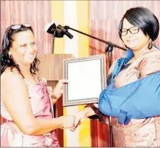  ?? (DPI photo) ?? Minister of Public Health Volda Lawrence (right) making a presentati­on to a staffer