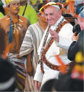  ?? PHOTO AFP ?? Reçu à Puerto Maldonado par différente­s tribus, le souverain pontife a enfilé une couronne de plumes et des colliers traditionn­els.