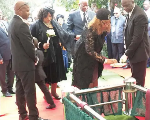  ?? The Sowetan/NEO GOBA ?? DUST-TO-DUST . . . Madikizela-Mandela’s daughters Zenani and Zindziswa Mandela queue up to pour sand onto their mother’s casket at Fourways Memorial Park, Johannesbu­rg, on Saturday. —