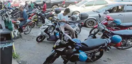  ?? PIC BY FATHIL ASRI ?? Motorcycli­sts parking in spaces meant for cars in Jalan Kuala Krai, Kota Baru, recently.