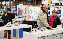  ?? Erik Verduzco/Associated Press ?? Bob Adkison and his wife Rosie, right, browse computer tablets at a Best Buy. Many stores are offering bigger discounts.