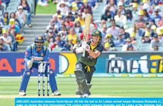  ??  ?? ADELAIDE: Australian batsman David Warner (R) hits the ball as Sri Lankan wicket keeper Niroshan Dickwella (L) looks on during the first internatio­nal T20 cricket match between Australia and Sri Lanka at the Adelaide Oval yesterday. — AFP