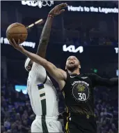  ?? THEARON W. HENDERSON — GETTY IMAGES ?? Stephen Curry #30of the Golden State Warriors goes to the basket against Bobby Portis #9of the Milwaukee Bucks during the first quarter at Chase Center on March 11 in San Francisco.