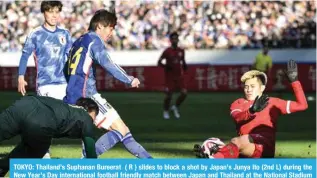  ?? – AFP ?? TOKYO: Thailand’s Suphanan Bureerat ( R ) slides to block a shot by Japan’s Junya Ito (2nd L) during the New Year’s Day internatio­nal football friendly match between Japan and Thailand at the National Stadium in Tokyo on January 1, 2024.