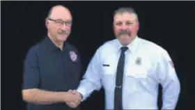  ?? COURTESY PHOTO ?? Retiring St. Louis Area Fire Department Chief Rich Apps, left, congratula­tes Lt. Bill Coty, an 18-year member of the department, for being selected as his successor. Coty will take over Oct. 21.