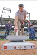  ?? MORRY GASH/THE ASSOCIATED PRESS ?? Major League Baseball Vice President of On-Field Strategy Joe Martinez compares the new, larger bases with the smaller, older bases Tuesday in Scottsdale, Ariz.